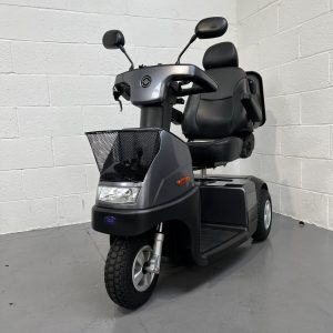 Dark grey 3 wheeled scooter with basket at the front and detachable bag at the rear. Fully adjustable swivel seat