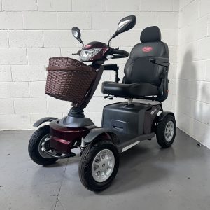 Black 4 wheeled mobility scooter with pilot seat and brown basket and headlights